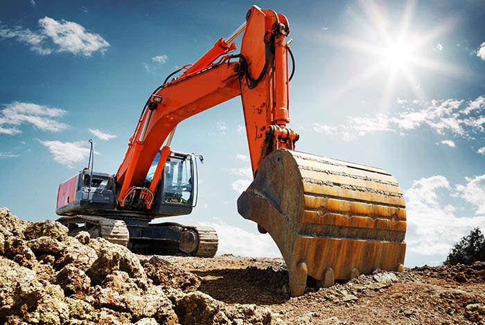 Ein großer orangener Bagger im Einsatz beim graben.